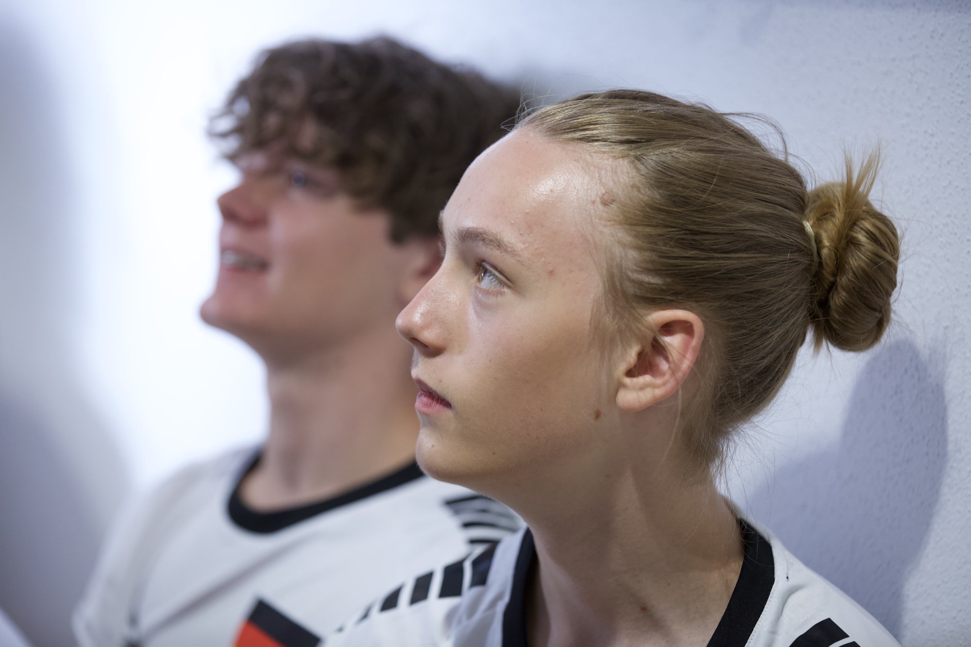 Mannschaft in weißen Trikots an der Wand der Umkleide