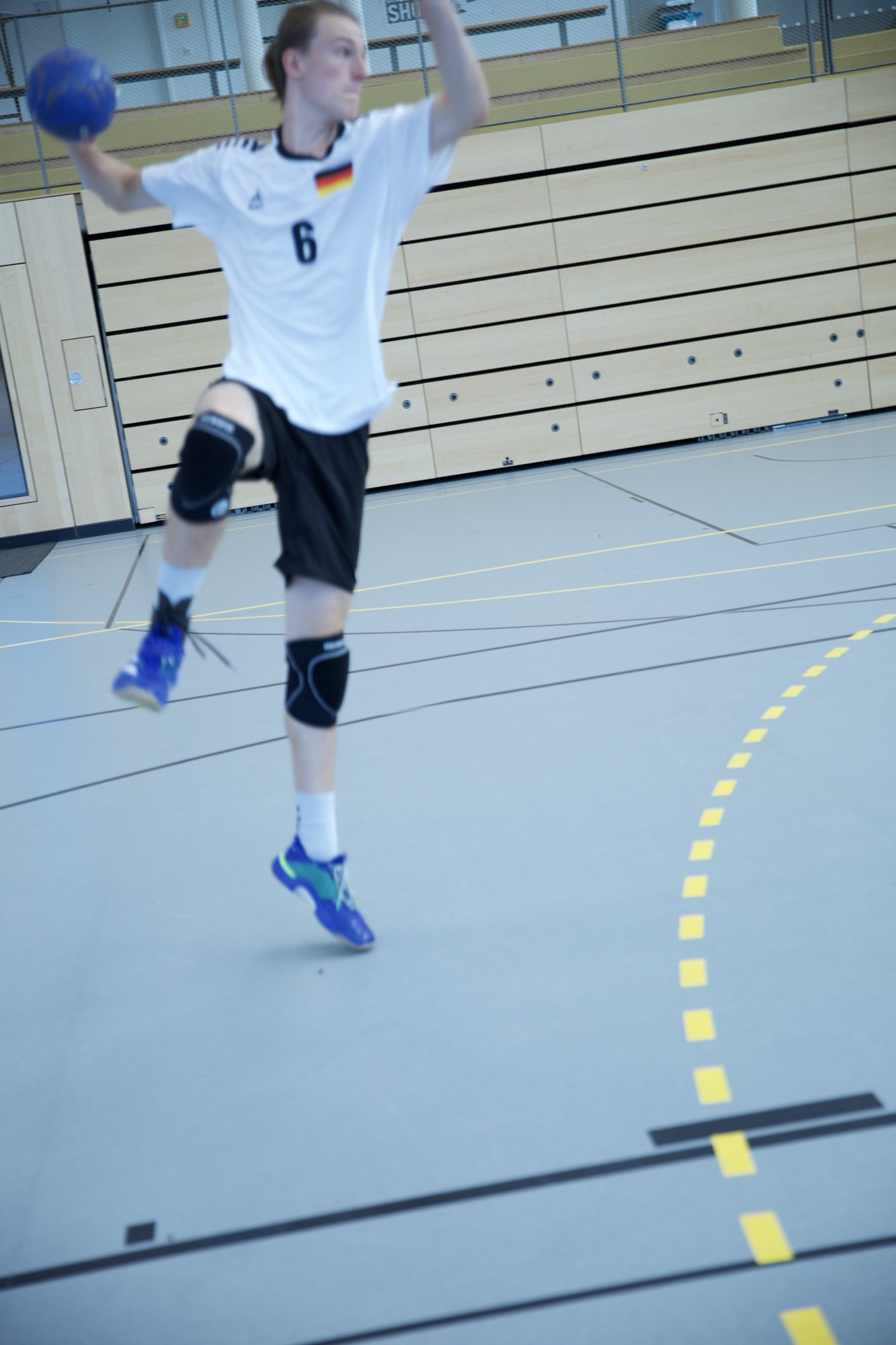 Handballspieler im Sprungwurf mit erhobenem Ball